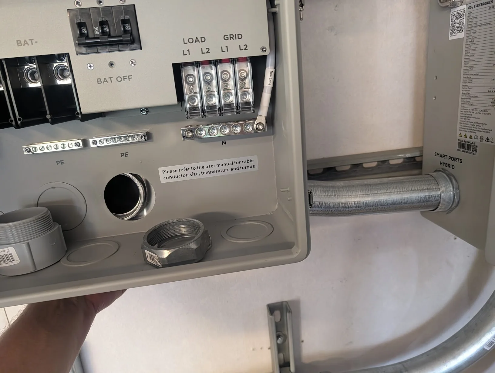 Slightly-bent EMT held in position between the two enclosures, aligned with both hubs