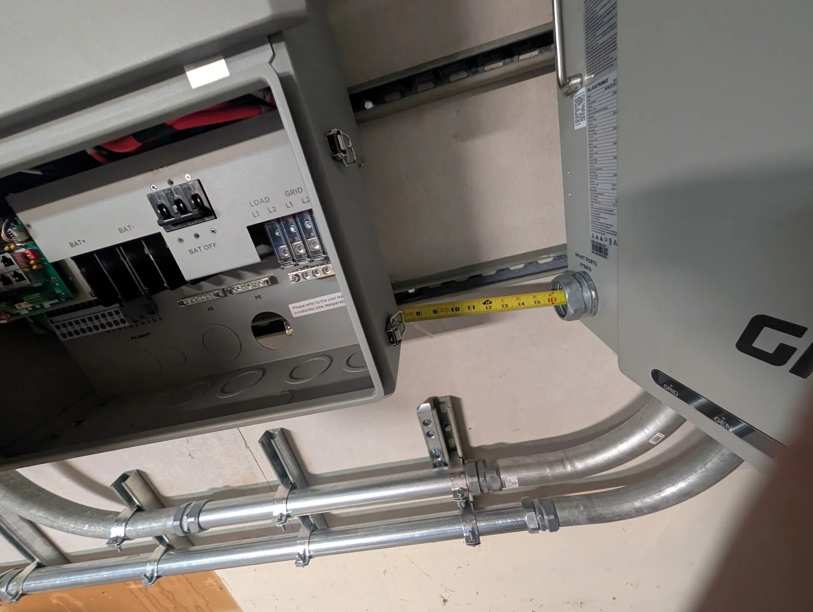Tape measure stretched between the GridBoss and FlexBoss to size the EMT cut