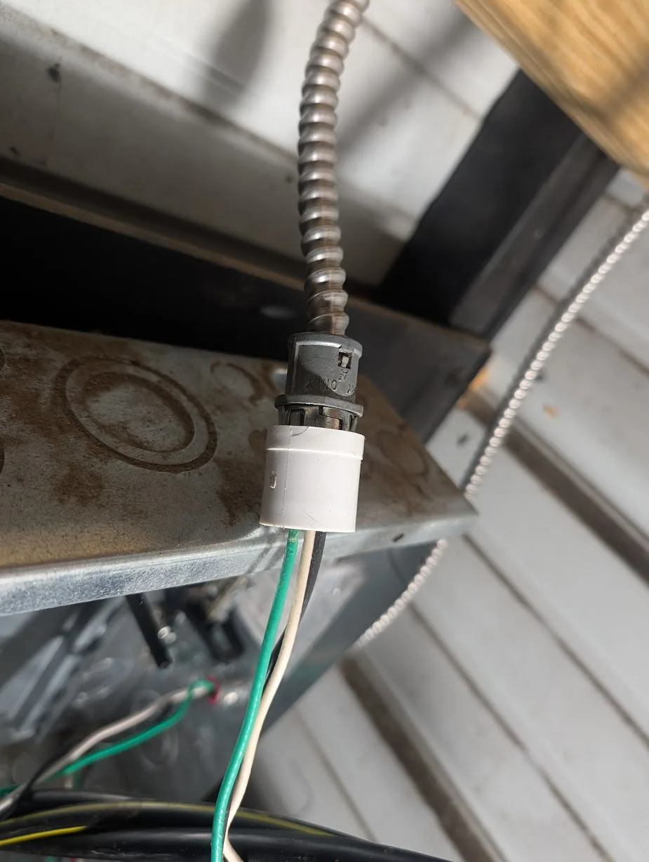Small pipe coupling used as a tool to depress the locking tab on an MC cable connector