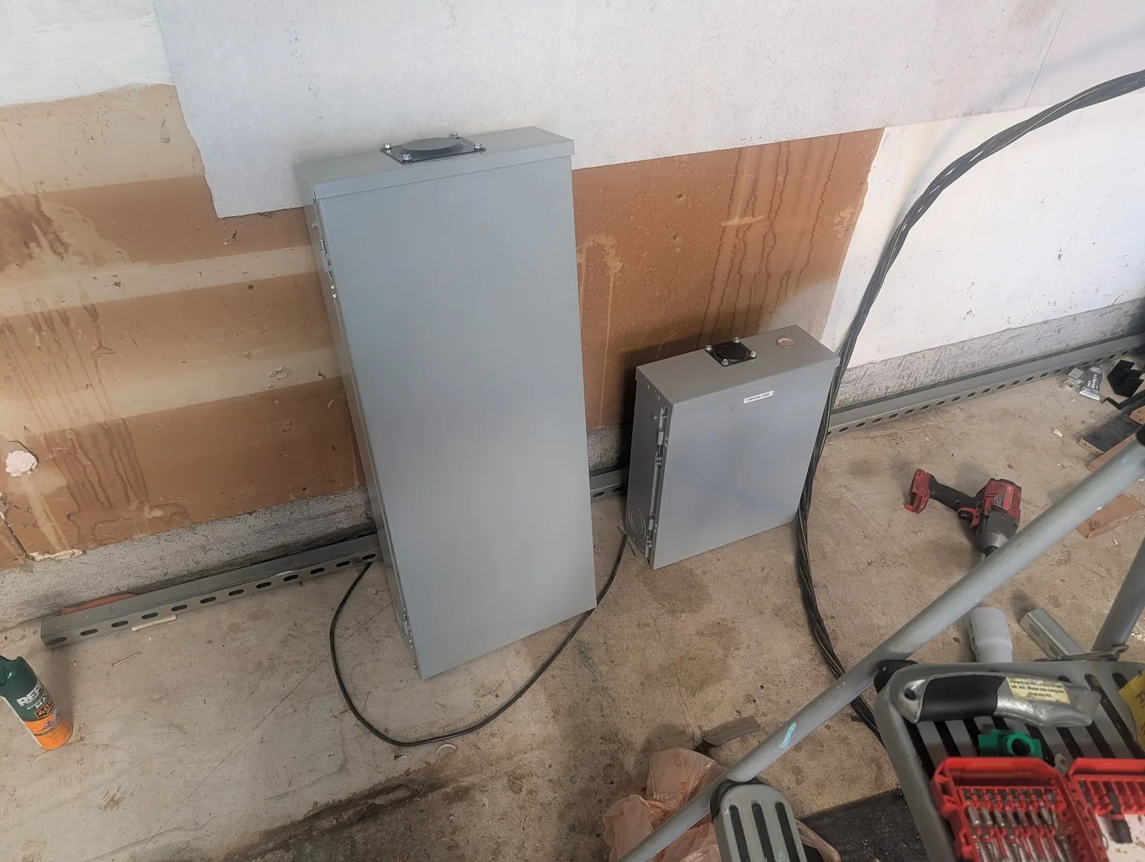 New 200A main load center and the smaller 125A critical-loads subpanel staged on the floor