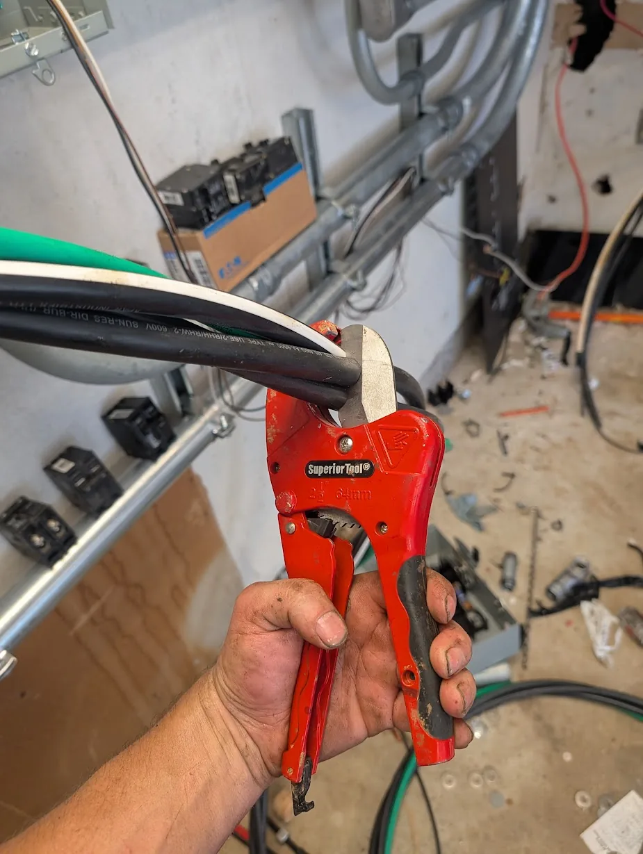 Ratcheting PVC pipe cutter being used to cleanly cut a section of 4/0 cable