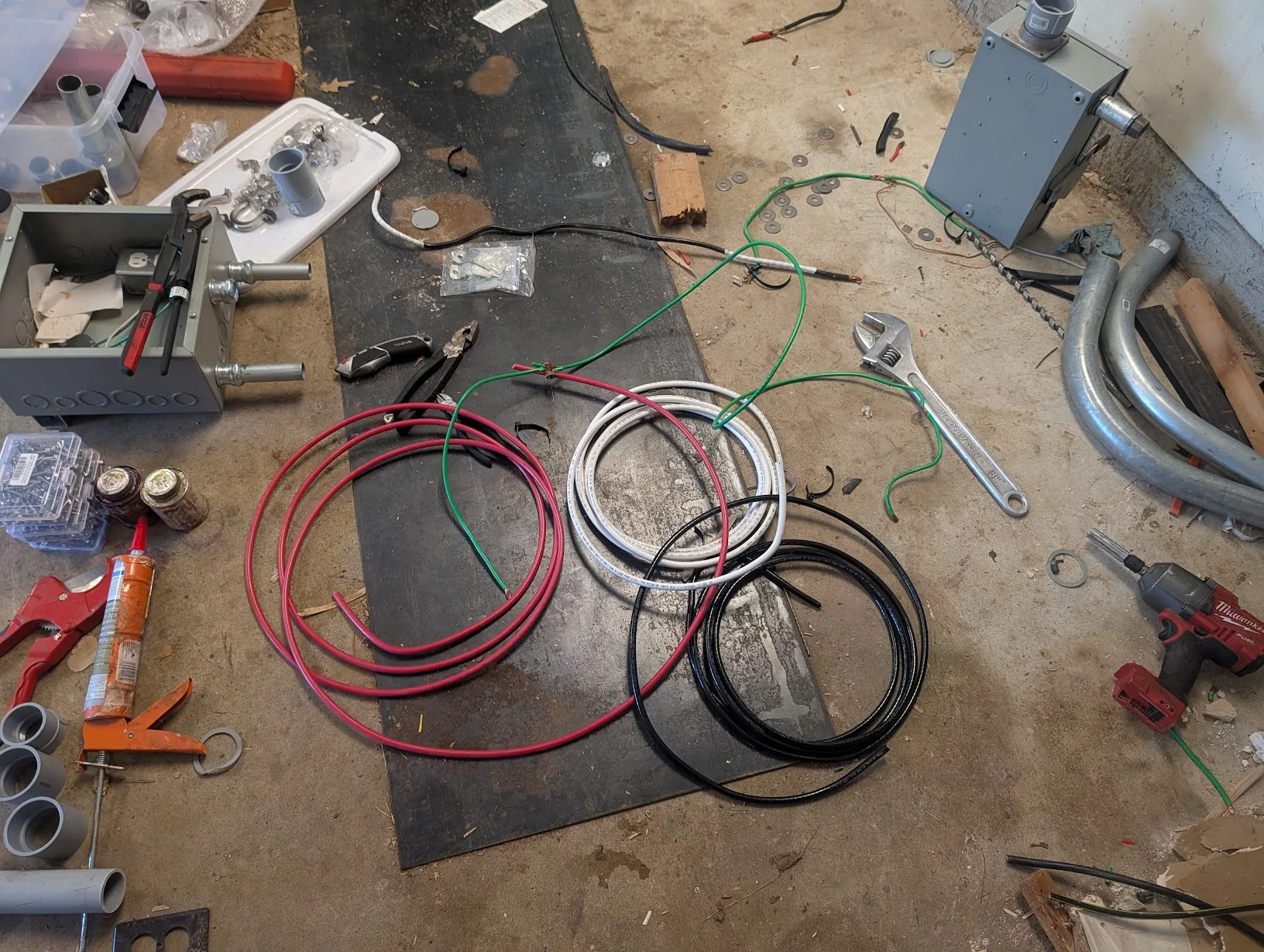 Coils of 2 AWG red/white/black copper THHN and green ground wire laid out on the shop floor
