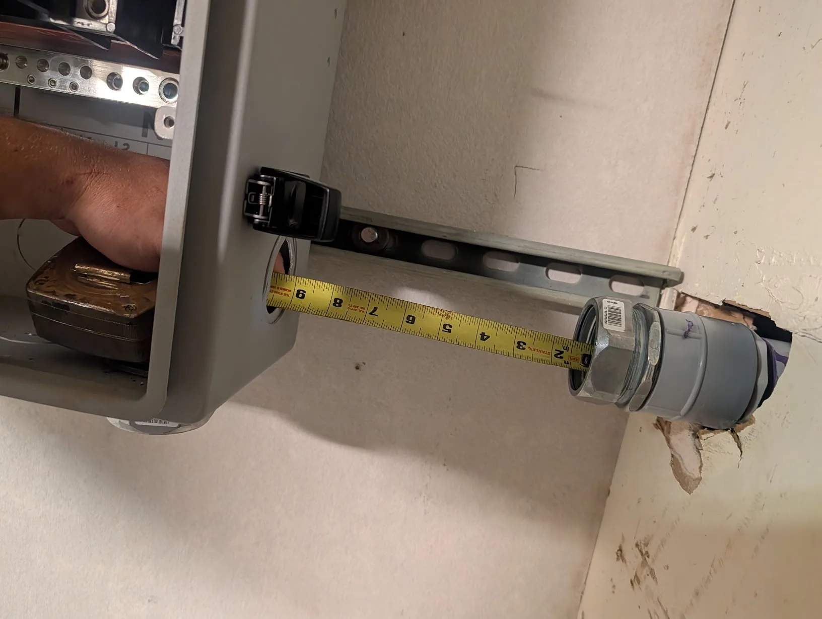 Measuring the 2" EMT stub between the GridBoss and the exterior wall fitting