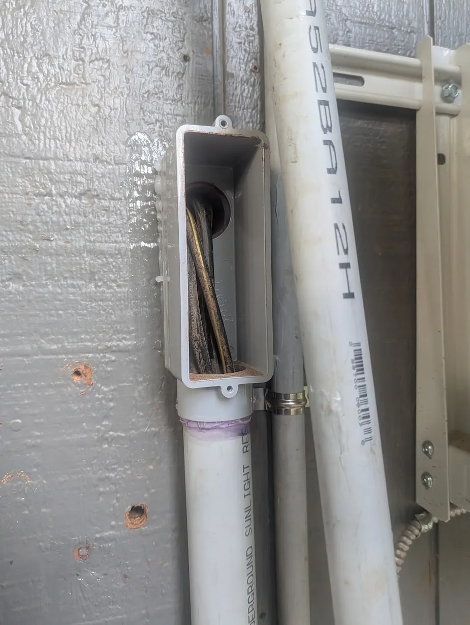 Cable pulled out of the LB-style entry box on the shop side, ready to terminate