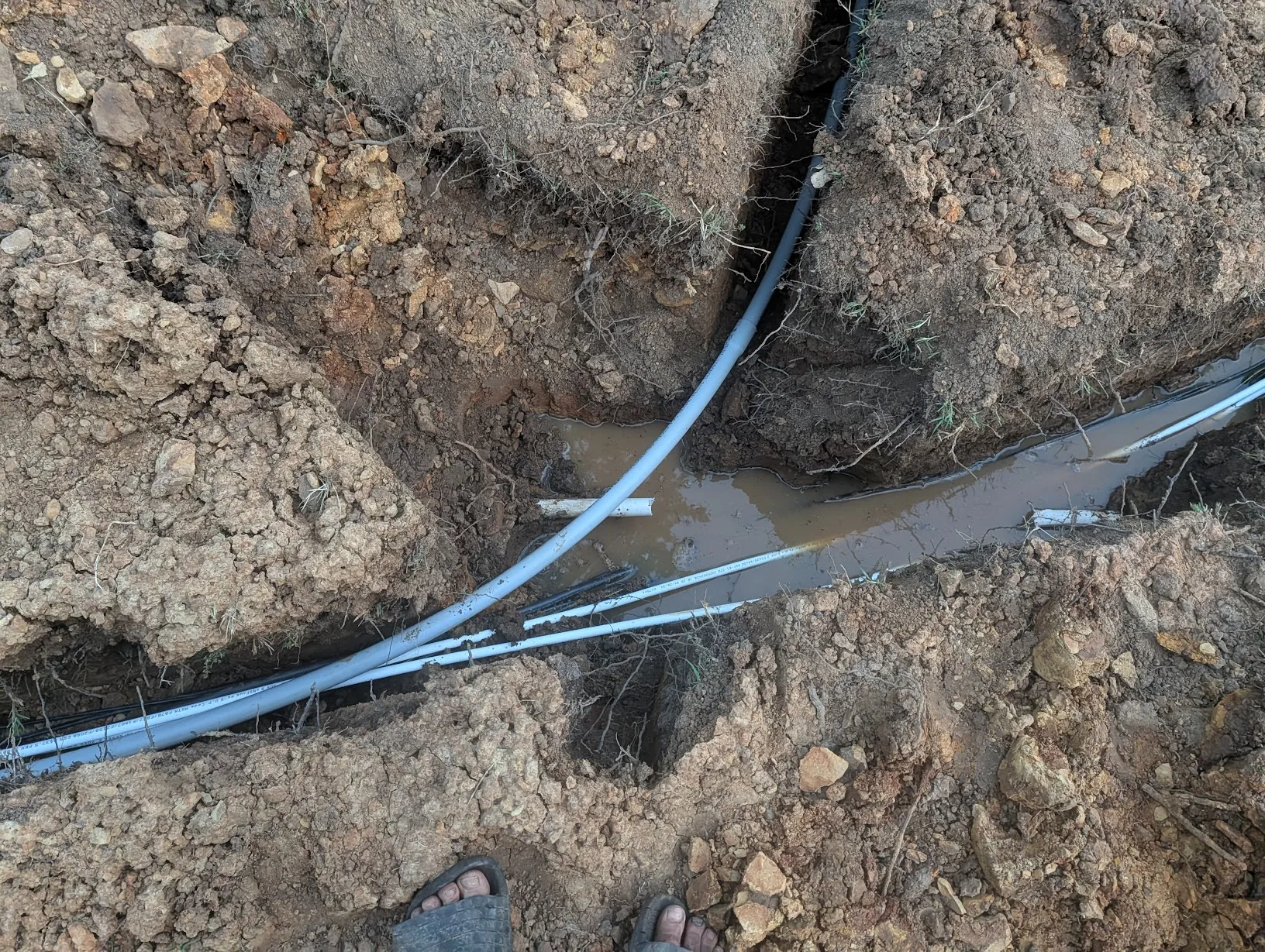 Conduit bent around the corner where two trenches meet