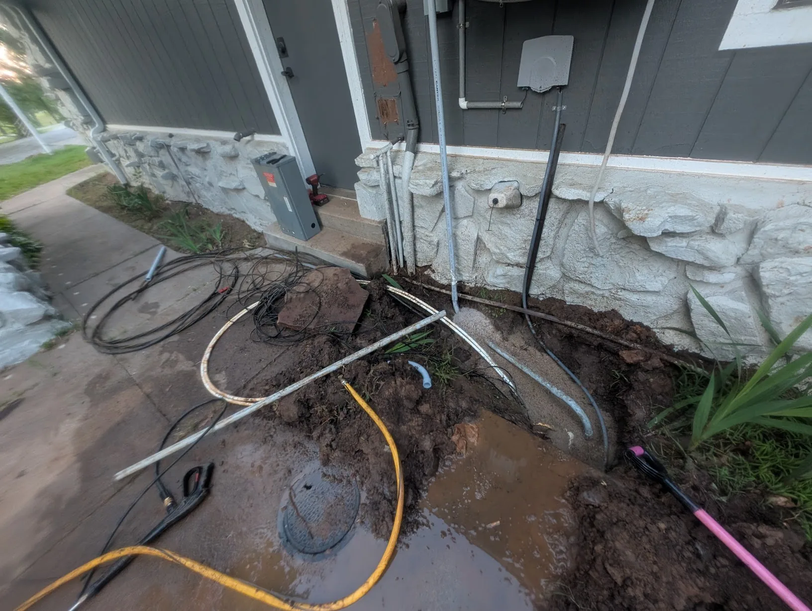 Conduit and cable buried in the flowerbed with sand for drainage