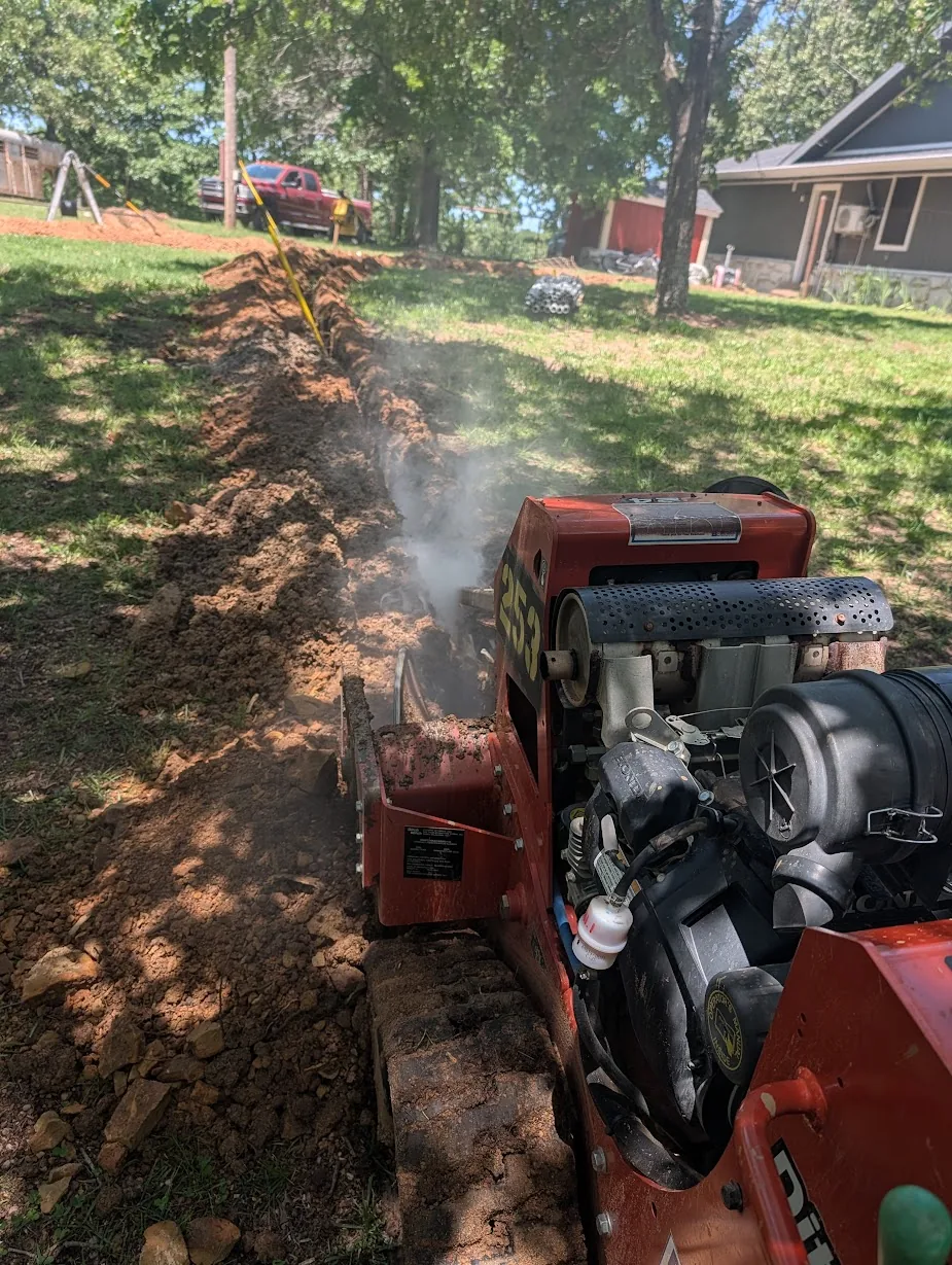 Trenching machine cutting through buried rock