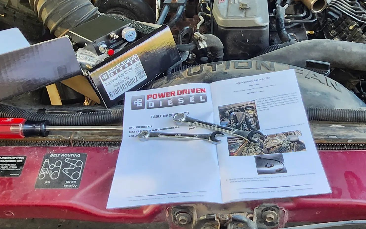 Image showing the instruction manual from Power Driven Diesel, with two wrenches on top of it.