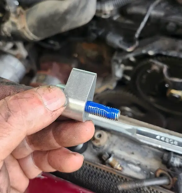 New bolt, with aluminum tab to cover dowel pin, with loctite applied