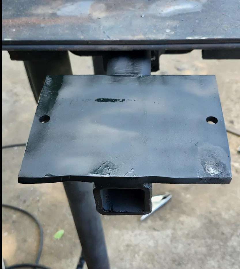 Photo of bench grinder mount, welding done, with coat of black paint.