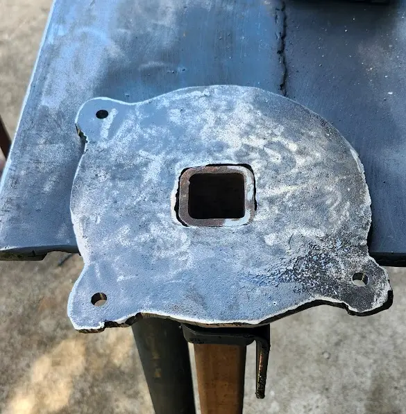 The plate with holes drilled, with a piece of square tubing, being test fit into the new mount