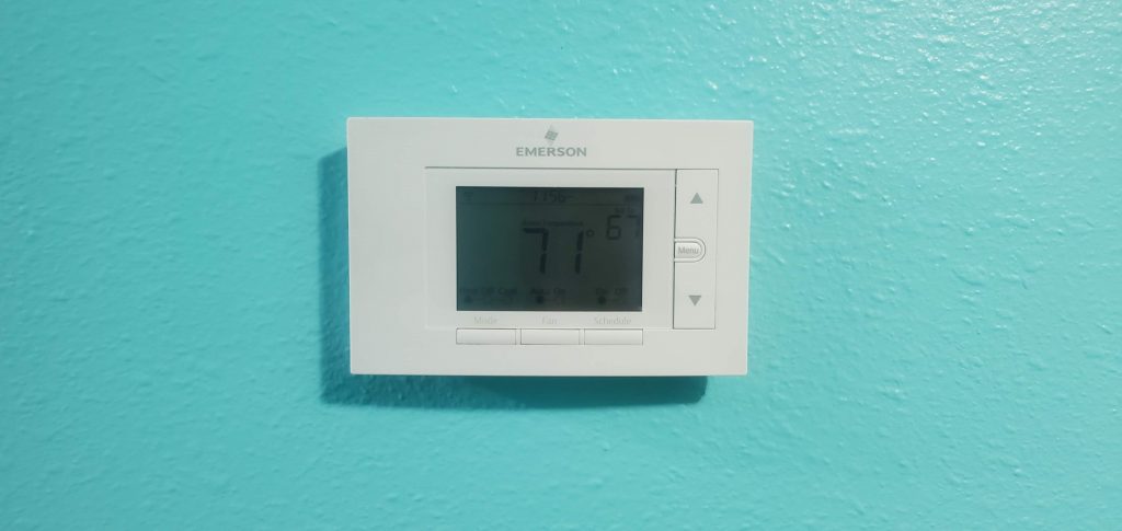 The old thermostat mounted on the wall